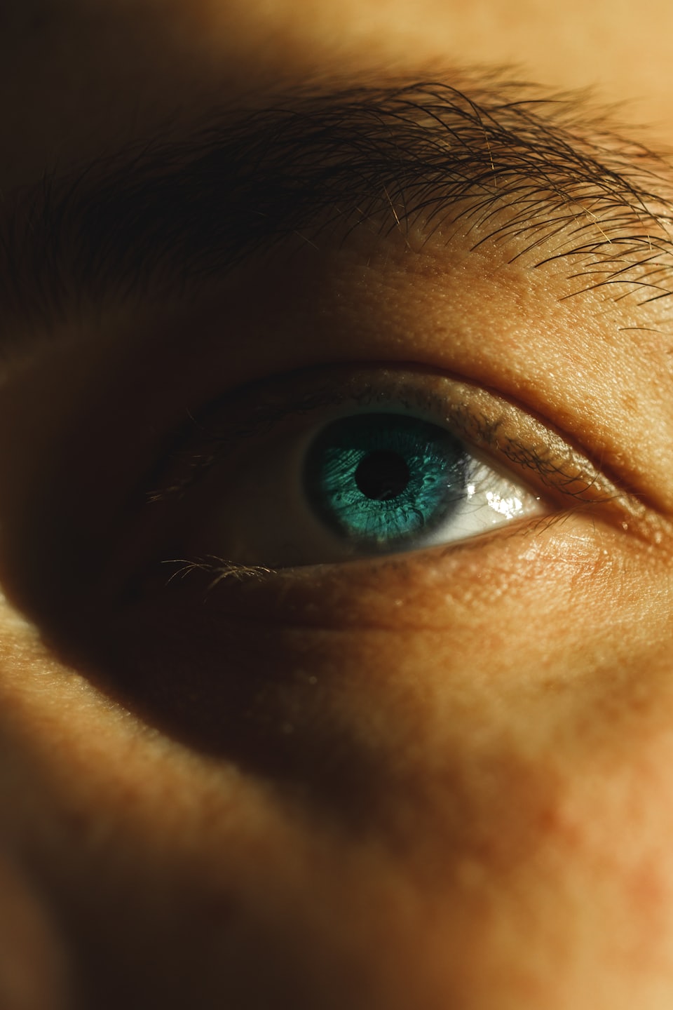 A closeup image of a human eye. Showing a turquoise iris looking to the left of frame. Eyes of Britain. Iris photography. Eye photography. Photography project. UK